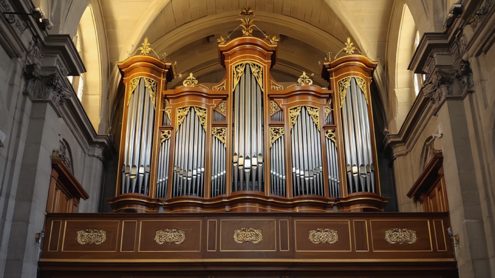 Prospekt einer historischen Orgel mit dicht gereihten Metallpfeifen, warmes Streiflicht auf Zinn und Holz des barocken Gehäuses
